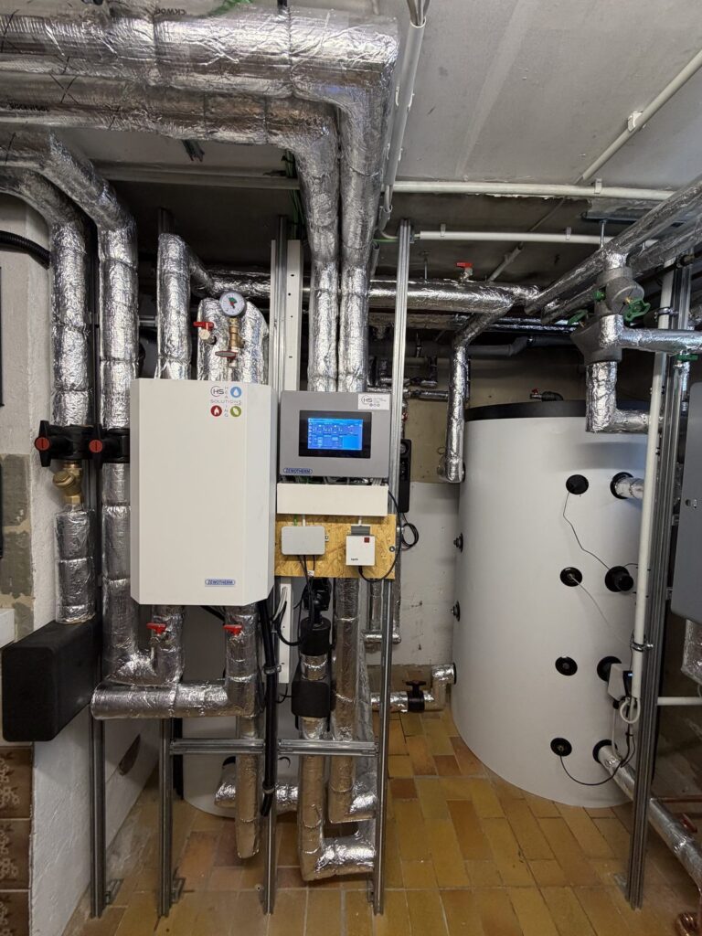 Technikzentrale der Wärmepumpen-Kaskade mit Hydraulikmodul, Regelung und Pufferspeicher
