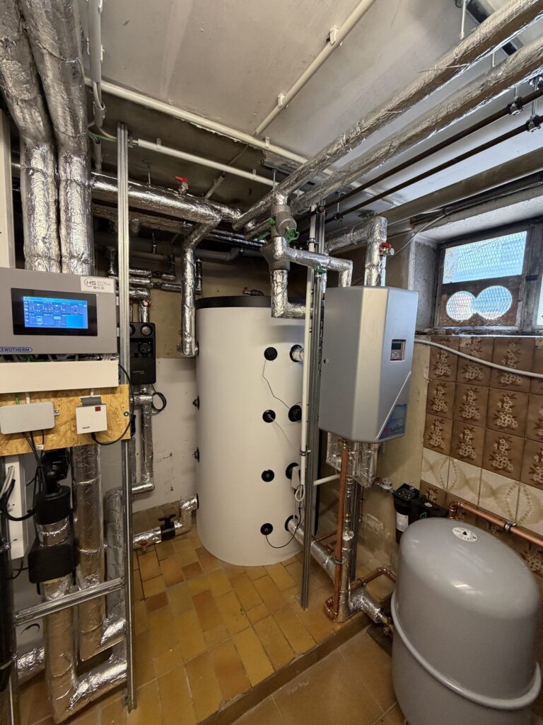 Pufferspeicher und Frischwasserstation im Heizungsraum des Mehrparteienhauses