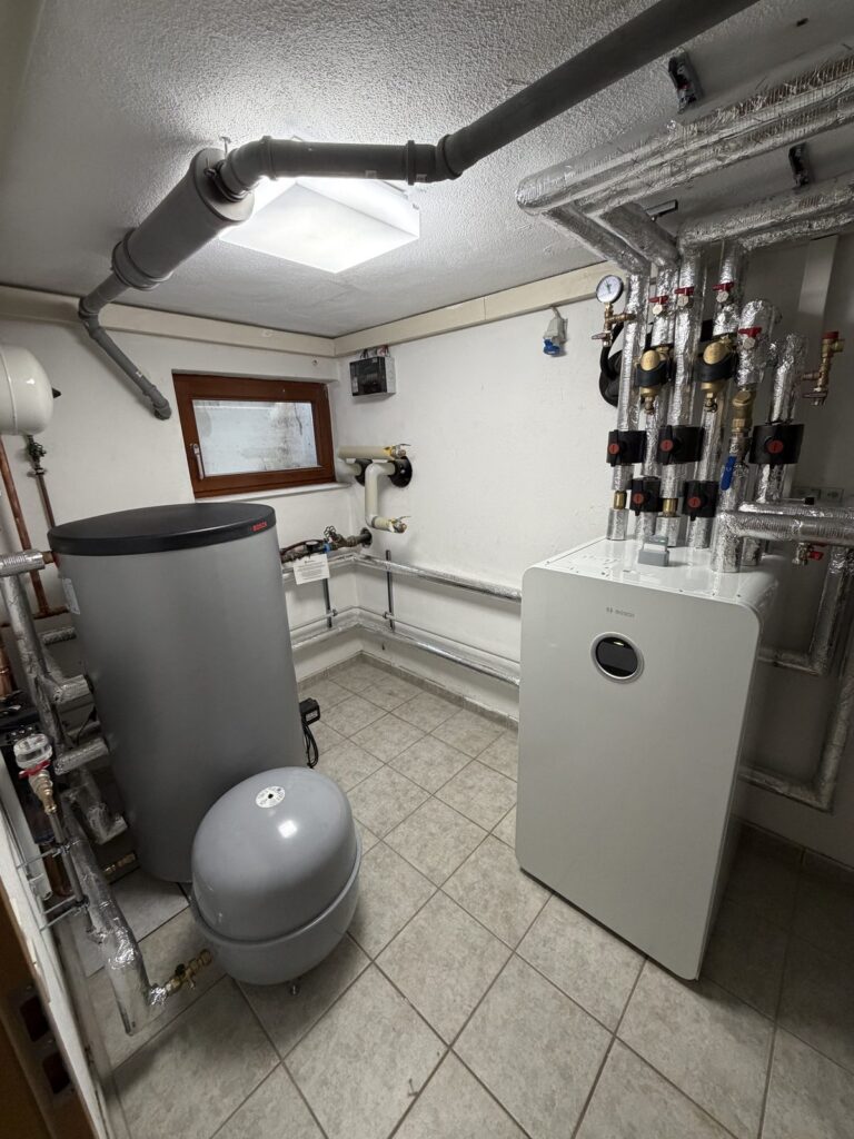Heizungsraum mit Inneneinheit, Warmwasserspeicher und hydraulischer Einbindung der beiden Heizkreise